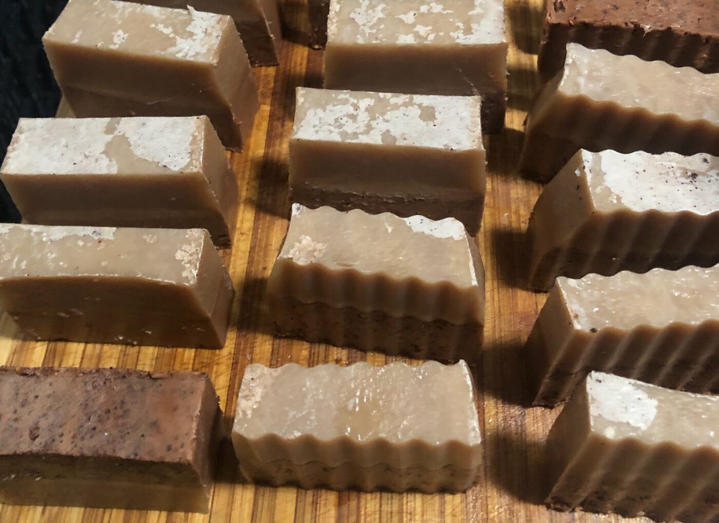 Hand-cut handmade soap bars in small batches on a wooden work surface
